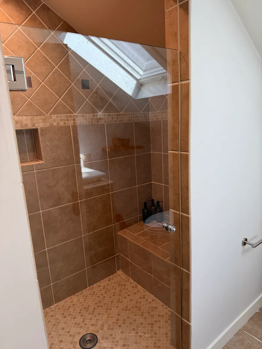 Upstairs bathroom — walk-in shower under the skylight