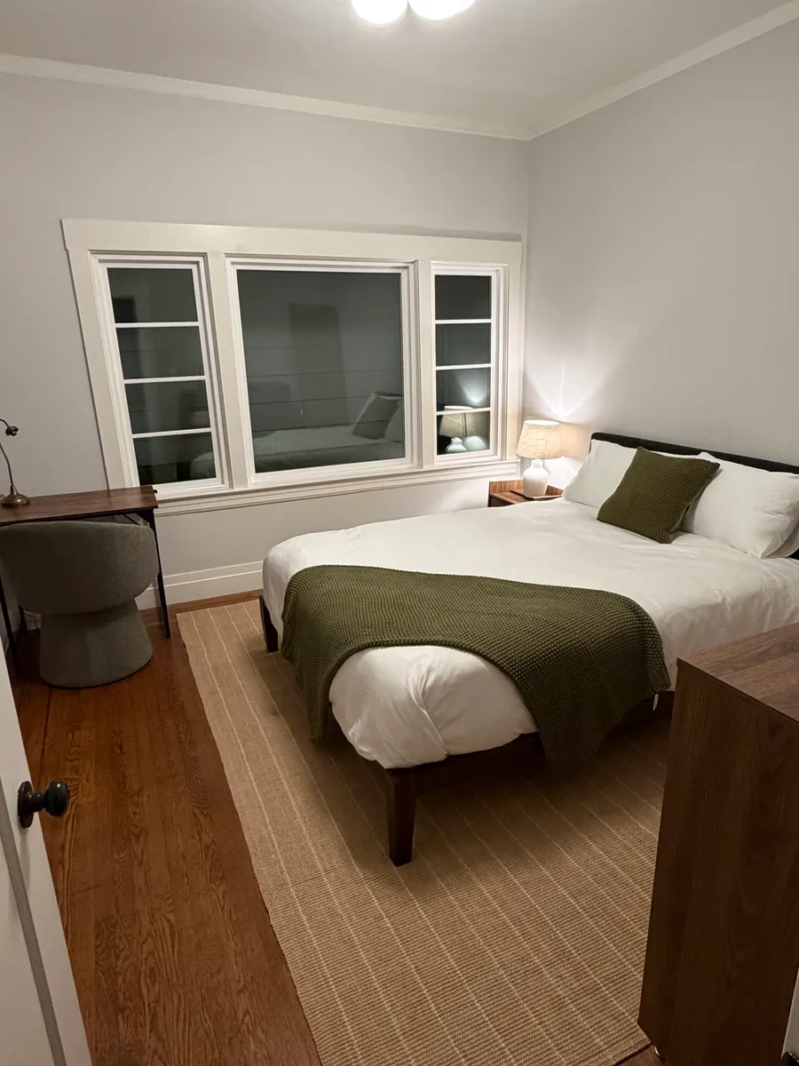 Fourth bedroom, downstairs — queen bed and a writing desk